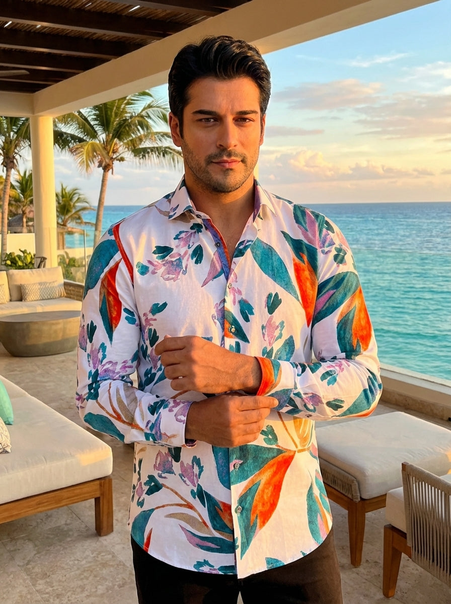 This vibrant men's long-sleeve button-down shirt features a bold, painterly floral and botanical print in teal, orange, and purple on a crisp white cotton base. Designed with a tailored fit, it includes contrasting inner cuffs and a sophisticated spread c