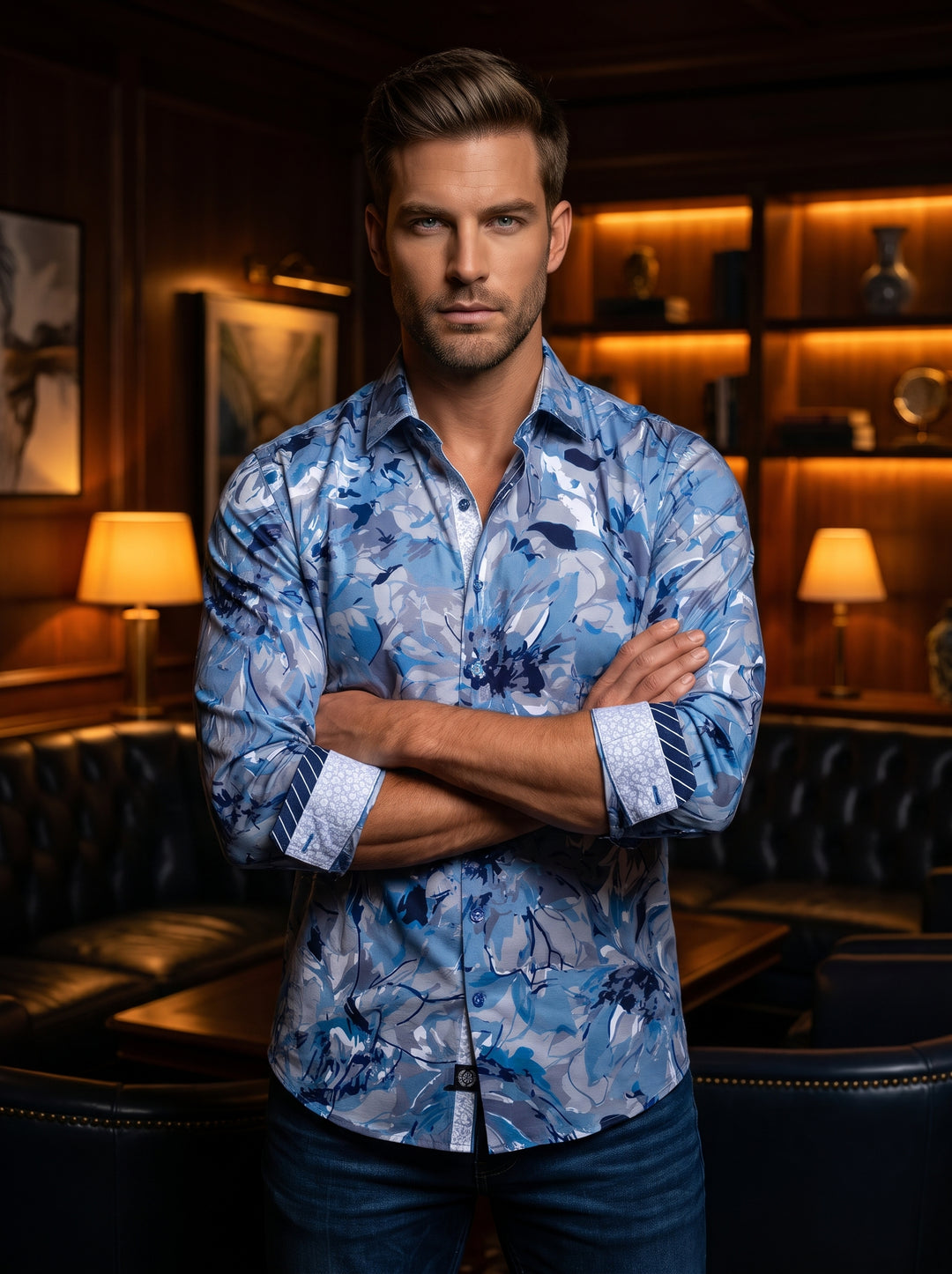 This men's long-sleeve button-down features a dynamic blue floral camouflage print in various shades of azure and navy. Designed with contrasting interior cuffs and a classic collar, this tailored piece offers a sophisticated yet artistic take on modern m