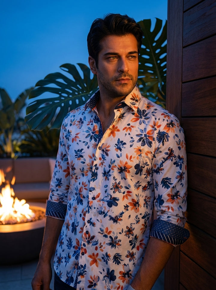 This men's long-sleeve button-down shirt features a vibrant white base adorned with an expressive blue and orange floral print. Contrasting navy patterned cuffs and a matching inner collar provide a sophisticated, multi-dimensional look suitable for styli