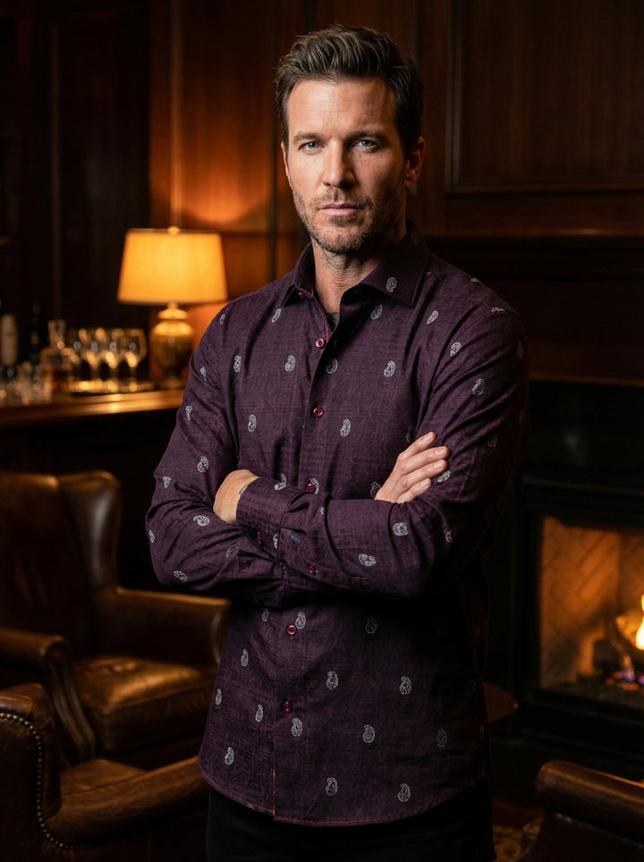 This sophisticated deep plum dress shirt by Masutto features a complex tonal damask weave layered with distinctive white paisley motifs. The garment boasts a sharp spread collar, coordinating burgundy buttons, and meticulous contrast stitching inside the 