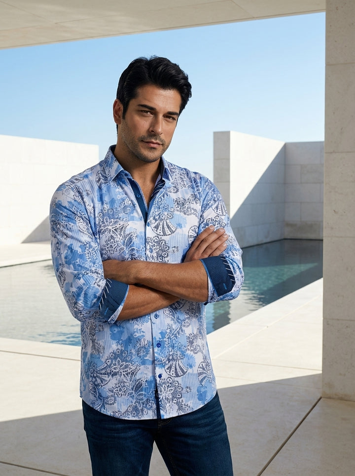 This men's long-sleeve button-down features a vibrant blue and white baroque floral print over a subtle vertical stripe. Contrasting navy patterned cuffs and collar trim add a sophisticated edge, while the tailored fit ensures a modern, polished silhouett