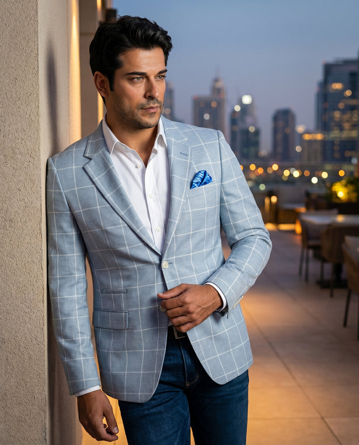 A refined light blue blazer featuring a subtle white windowpane check pattern and a notched lapel. This slim-fit jacket is styled with a crisp white button-down shirt, a patterned pocket square, and dark denim for a modern, sophisticated look.