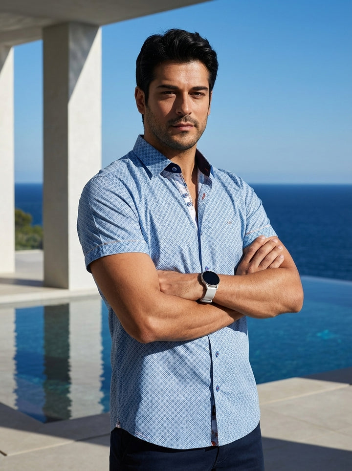 This tailored men's short-sleeve button-down features a sophisticated light blue geometric pattern with contrasting navy inner collar detailing. Crafted for a modern fit, the shirt includes distinctive accent buttons and a refined finish, making it an ess