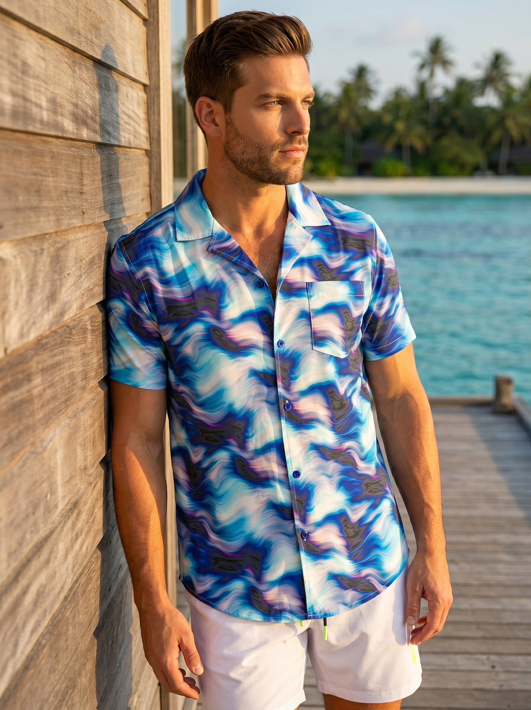 This vibrant men's button-down shirt features a dynamic blue and white marbled wave pattern with subtle purple and charcoal accents. Designed with a classic camp collar, short sleeves, and a single chest pocket, it offers a relaxed yet stylish fit.