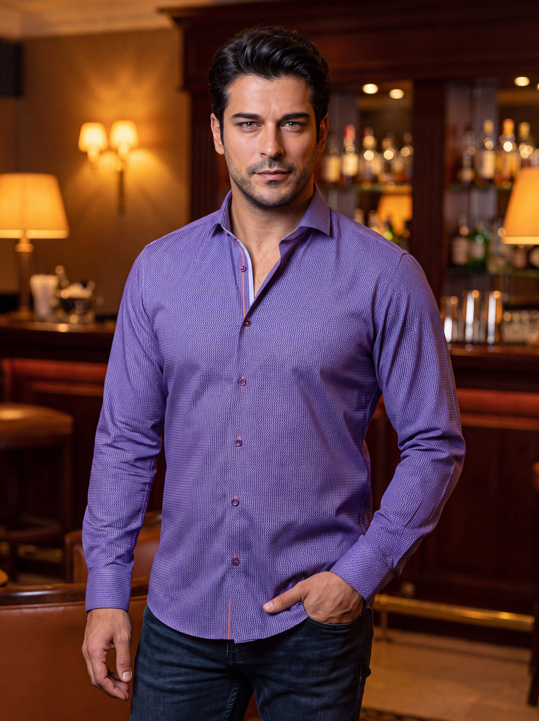 This men's long-sleeve button-down shirt features a vibrant purple hue with an intricate, textured geometric micro-pattern. It is accented with contrasting orange stitching and button details, offering a modern, slim-fit silhouette that pairs effortlessly