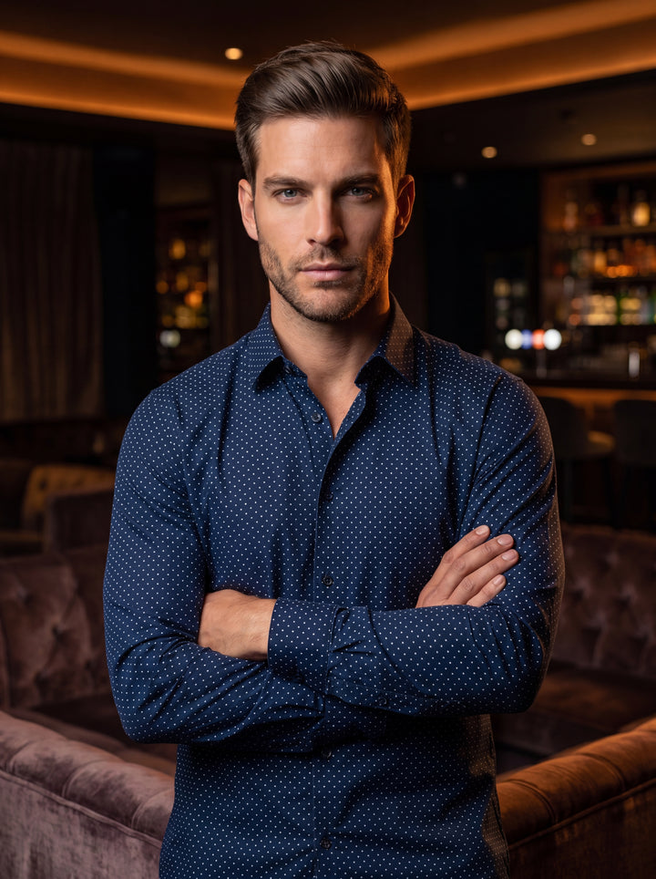 This sophisticated navy blue button-down shirt features a crisp, white micro-dot pattern and a refined tailored fit. Crafted with a classic pointed collar and long sleeves, it offers a sharp, contemporary look suitable for transitioning from day to night.