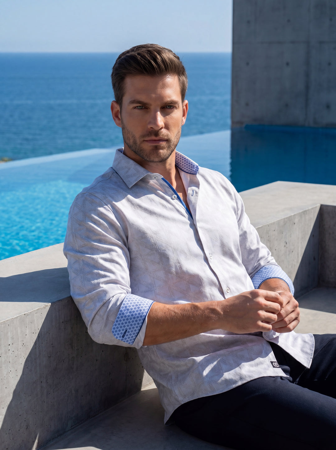 This sophisticated long-sleeve button-down shirt features a subtle geometric jacquard pattern in a light grey hue. Contrasting blue micro-print cuffs and interior collar trim provide a modern twist, while the tailored fit ensures a sharp, clean silhouette