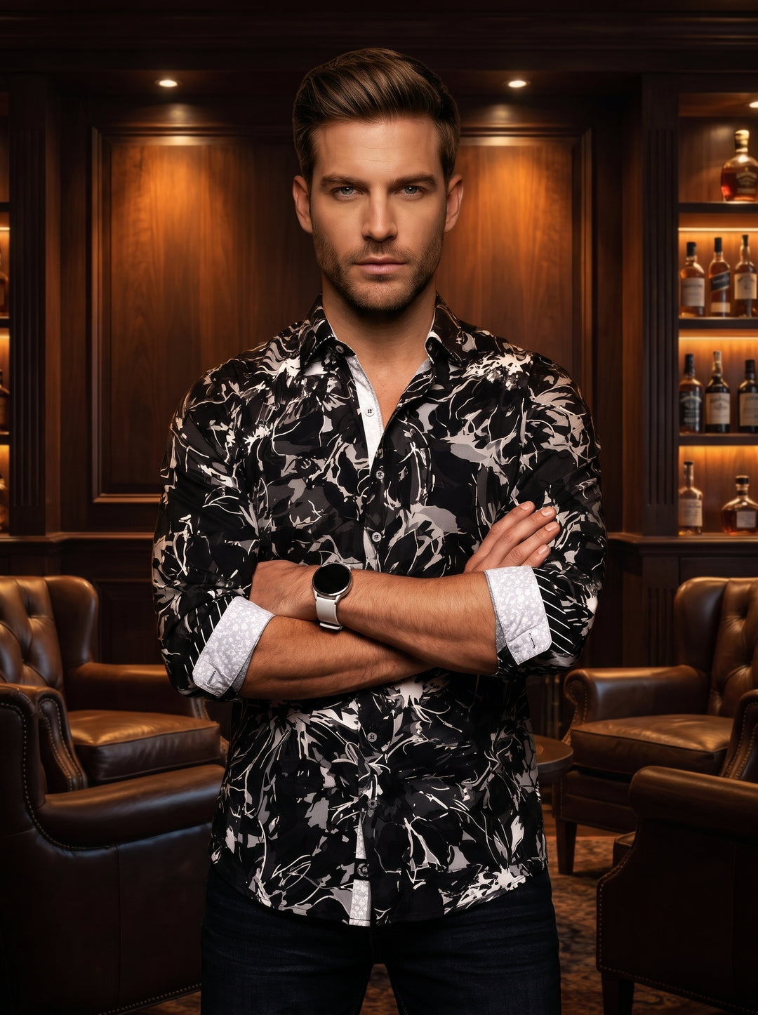 This bold button-down shirt features a dynamic abstract floral pattern in monochromatic black, grey, and white. Designed with a tailored fit, it includes contrasting white patterned cuffs and a button placket that adds a modern, sophisticated touch to the