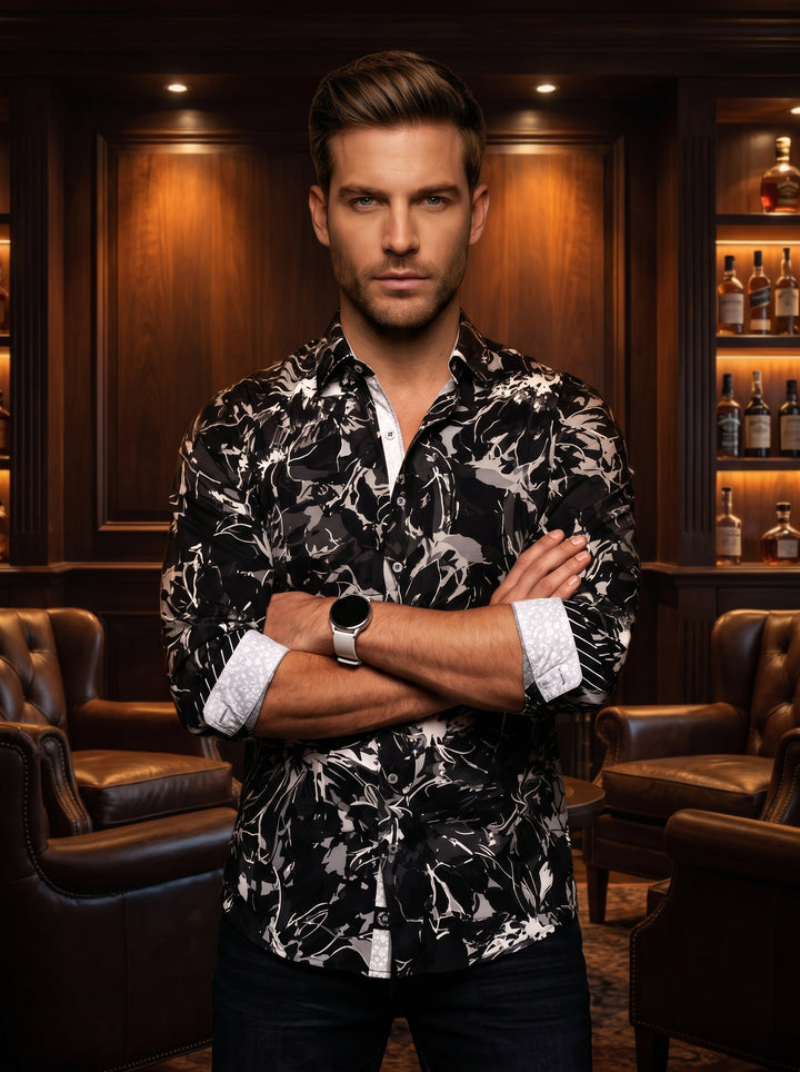 This bold button-down shirt features a dynamic abstract floral pattern in monochromatic black, grey, and white. Designed with a tailored fit, it includes contrasting white patterned cuffs and a button placket that adds a modern, sophisticated touch to the