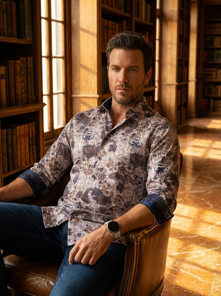 This sophisticated long-sleeve button-down shirt features an intricate paisley and floral motif in muted earth tones. Designed with contrasting dark navy patterned cuffs and a tailored fit, it offers a modern take on classic style for the discerning gentl