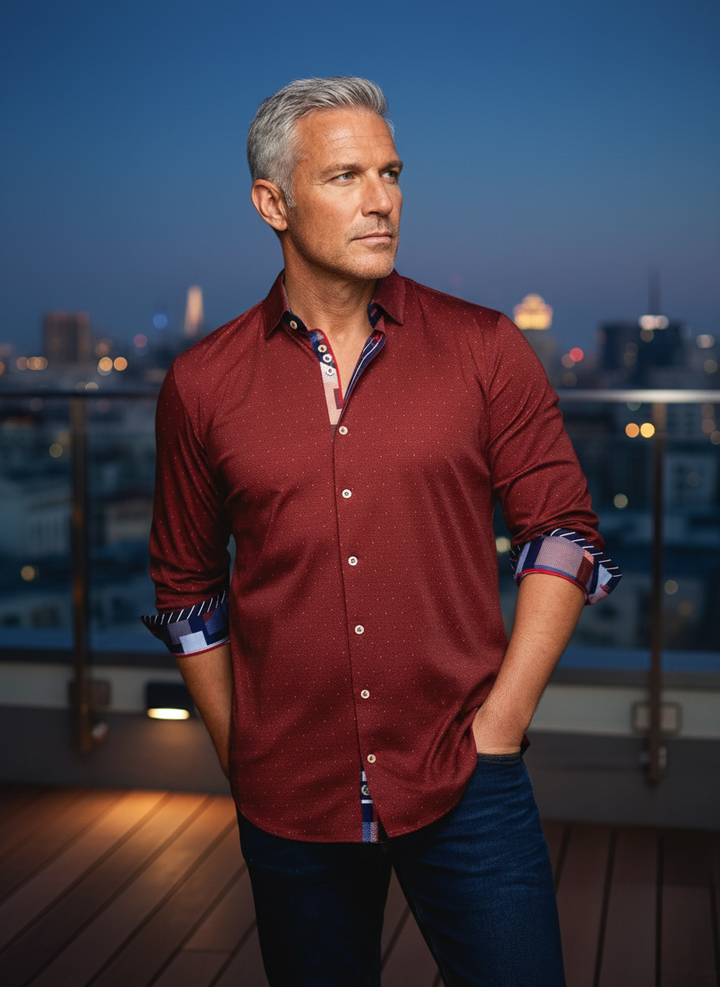 A sophisticated burgundy pinpoint dress shirt, featuring a subtle micro-dot pattern and distinctive contrasting inner collar and cuff linings in blue and white geometric designs. This modern fit offers effortless style for discerning individuals.