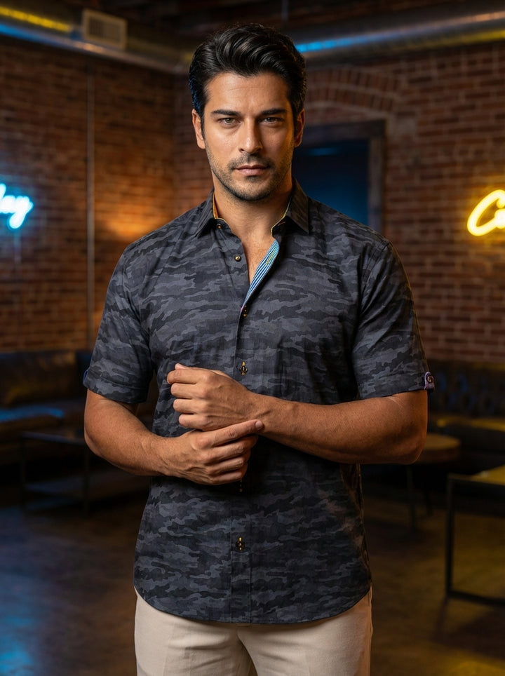 This men's short-sleeve button-down shirt features a modern charcoal and slate gray camouflage pattern. It includes unique contrasting details on the inner collar and placket, such as blue stripes and yellow accents, paired with stylishly cuffed sleeves a