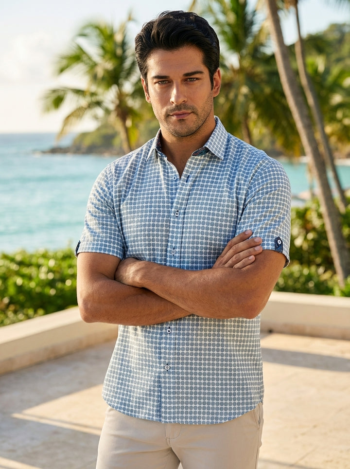 This men's short-sleeve button-down shirt features a refreshing blue and white geometric polka-dot pattern. Crafted with a classic collar and contrast inner lining, it offers a refined yet relaxed fit perfect for warm weather or casual social outings.