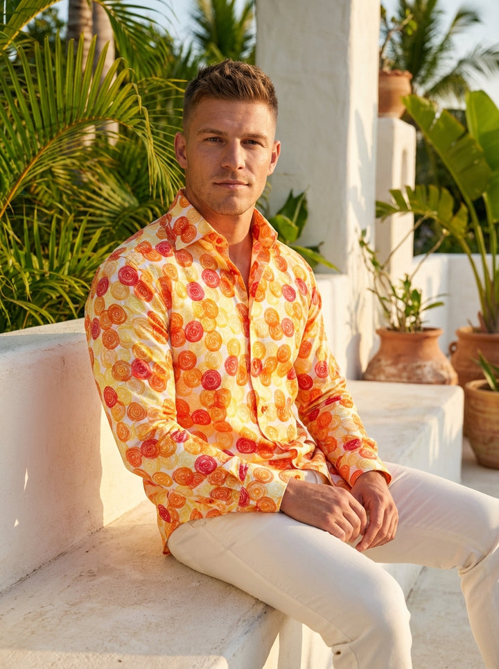 This Masutto button-down shirt features a vibrant, hand-sketched swirl print in shades of orange, yellow, and red on a white cotton base. The playful circular motifs and coordinating buttons create a bold, artistic statement piece perfect for warm-weather