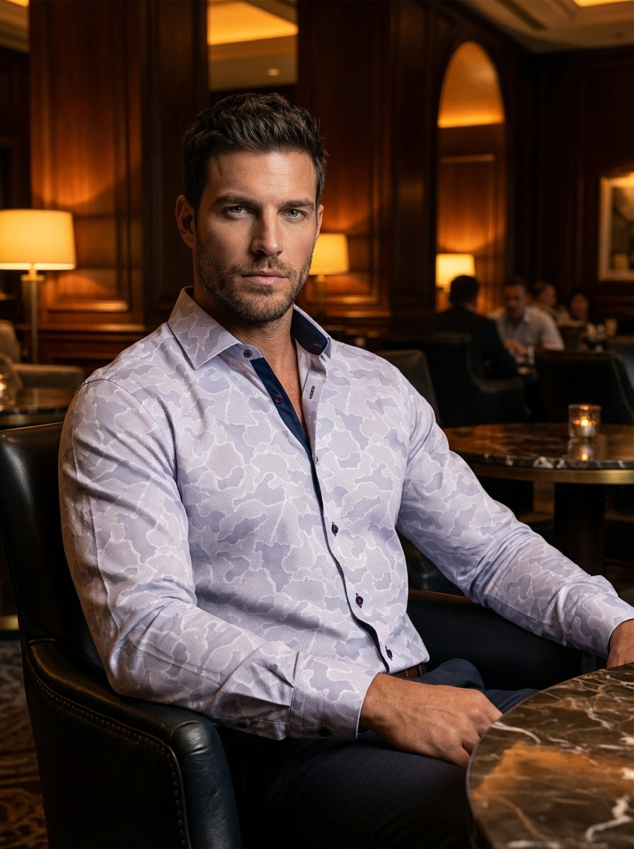 This sophisticated long-sleeve button-down features a contemporary pale purple and grey camouflage print on a micro-textured white fabric. It is accented with high-contrast navy inner collar lining and dark buttons with red stitching for a polished, moder